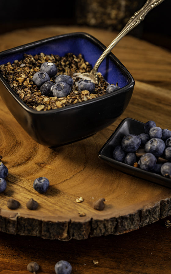 Bowl of Granola with Blueberries on wood background with blueberries by Julie L'Heureux Visual Media Strategy