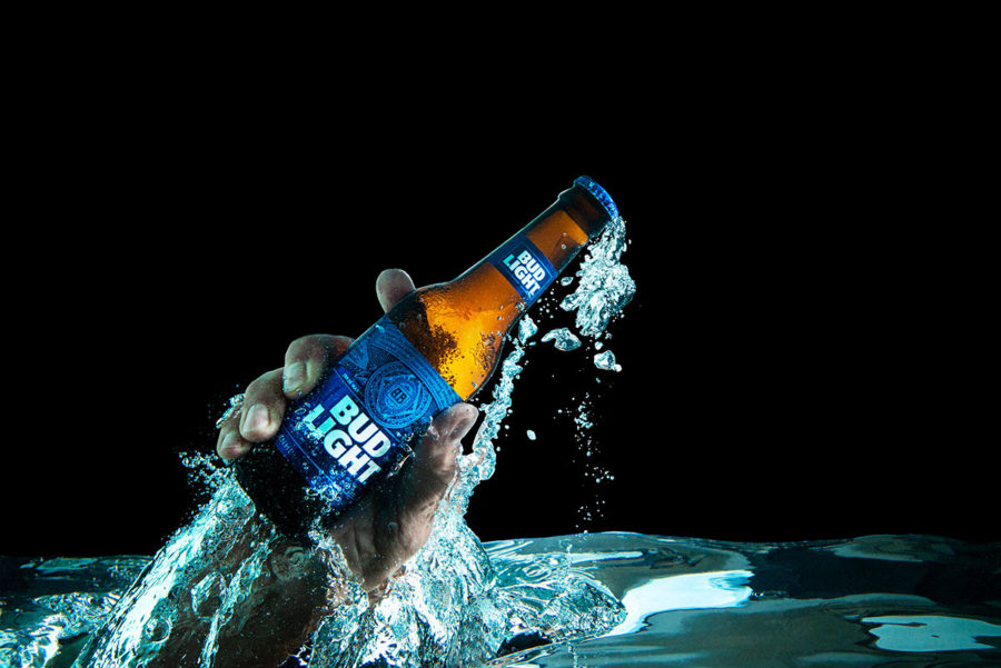 Hand holding a Bud Light Bottle thrusting up from below water Greg Kindred visual media strategy